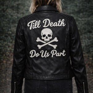 Puede incluir: Chaqueta de cuero negra con la frase "Till Death Do Us Part" y un diseño de calavera y huesos cruzados en la espalda. La chaqueta tiene un estilo motero clásico con cierre de cremallera.