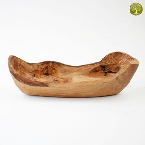 Könnte beinhalten: Eine handgefertigte Holzschale mit einer natürlichen, organischen Form. Die Schale besteht aus hellbraunem Holz mit dunkleren braunen Maserungen und Knoten. Die Ränder haben eine natürliche, unebene Form, und die Schale ist leer.