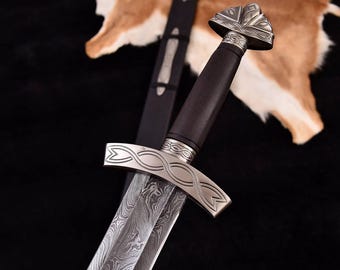May include: A silver sword with a dark wood handle and intricate metalwork. The blade has a patterned design and the pommel is shaped like a flower.