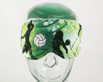 Puede incluir: Máscara para dormir verde y blanca con un balón de voleibol y una silueta de jugadores.