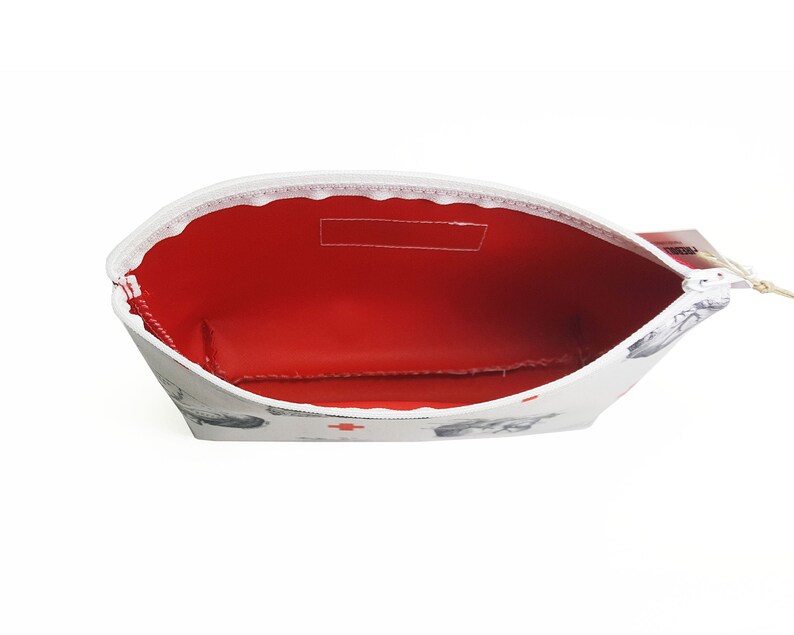 May include: White zippered pouch with a red interior and a white and grey print of small animals. The pouch is open and the zipper is pulled down.