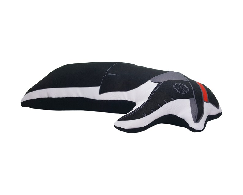 May include: Black and white plush pillow shaped like a dachshund dog. The dog is lying down with its head turned to the side. The pillow has a red stripe around the neck and a grey nose.