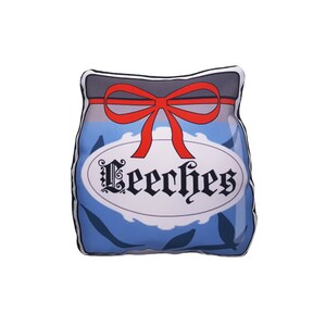 May include: A blue and white pillow shaped like a jar with a red bow and the word "Leeeches" written on the label.