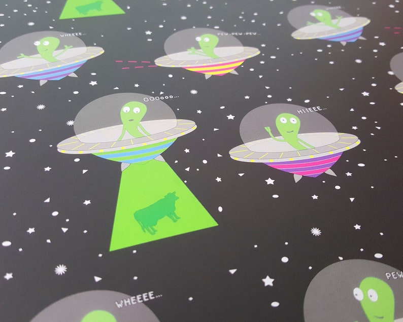 May include: A black background with a repeating pattern of green aliens in flying saucers. The aliens are saying different phrases like "Wheee...", "Pew Pew Pew", "Hiiiiieeee...", "Ooooo...", and "Wheeee..."  The aliens are green with black eyes and mouths. The saucers are gray with colorful stripes. There are white stars and triangles scattered across the background.