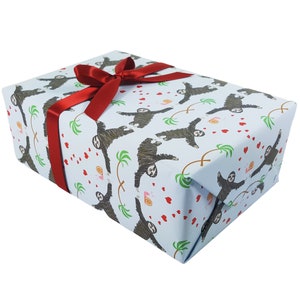May include: A light blue gift wrap with a pattern of sloths holding hearts and palm trees. A red ribbon is tied around the box.