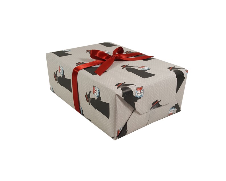 May include: A gift box wrapped in gray wrapping paper with a black and white pattern of a person holding a jar. The box is tied with a red ribbon.