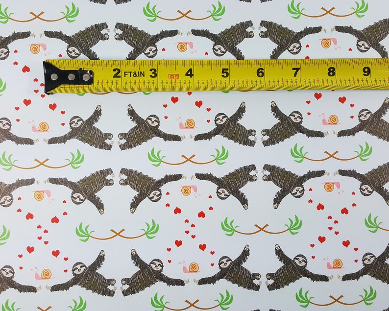 May include: A white background with a repeating pattern of brown sloths hanging upside down with their arms outstretched. The sloths are surrounded by small red hearts, pink snails, and green palm leaves. A yellow measuring tape is placed across the top of the image with the numbers 2, 3, 4, 5, 6, 7, 8, and 9 visible.