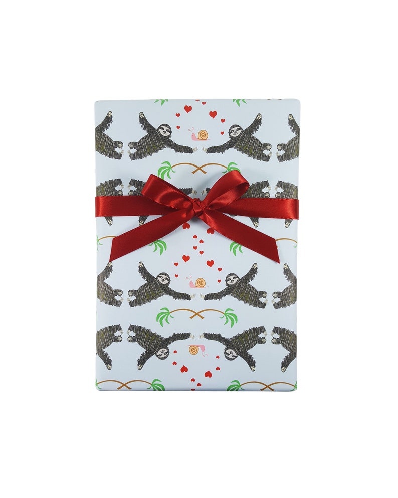 May include: A blue gift wrap with a pattern of sloths, palm trees, hearts, and snails. The gift is tied with a red ribbon.