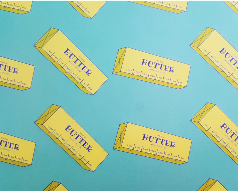 May include: A pattern of yellow butter boxes with the word "BUTTER" in navy blue, set against a teal background. Each box has measurement markings. The boxes are oriented at various angles.