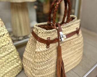 Borsa a mano con pompon: in foglia di palma intrecciata, trendy ed ecologica.