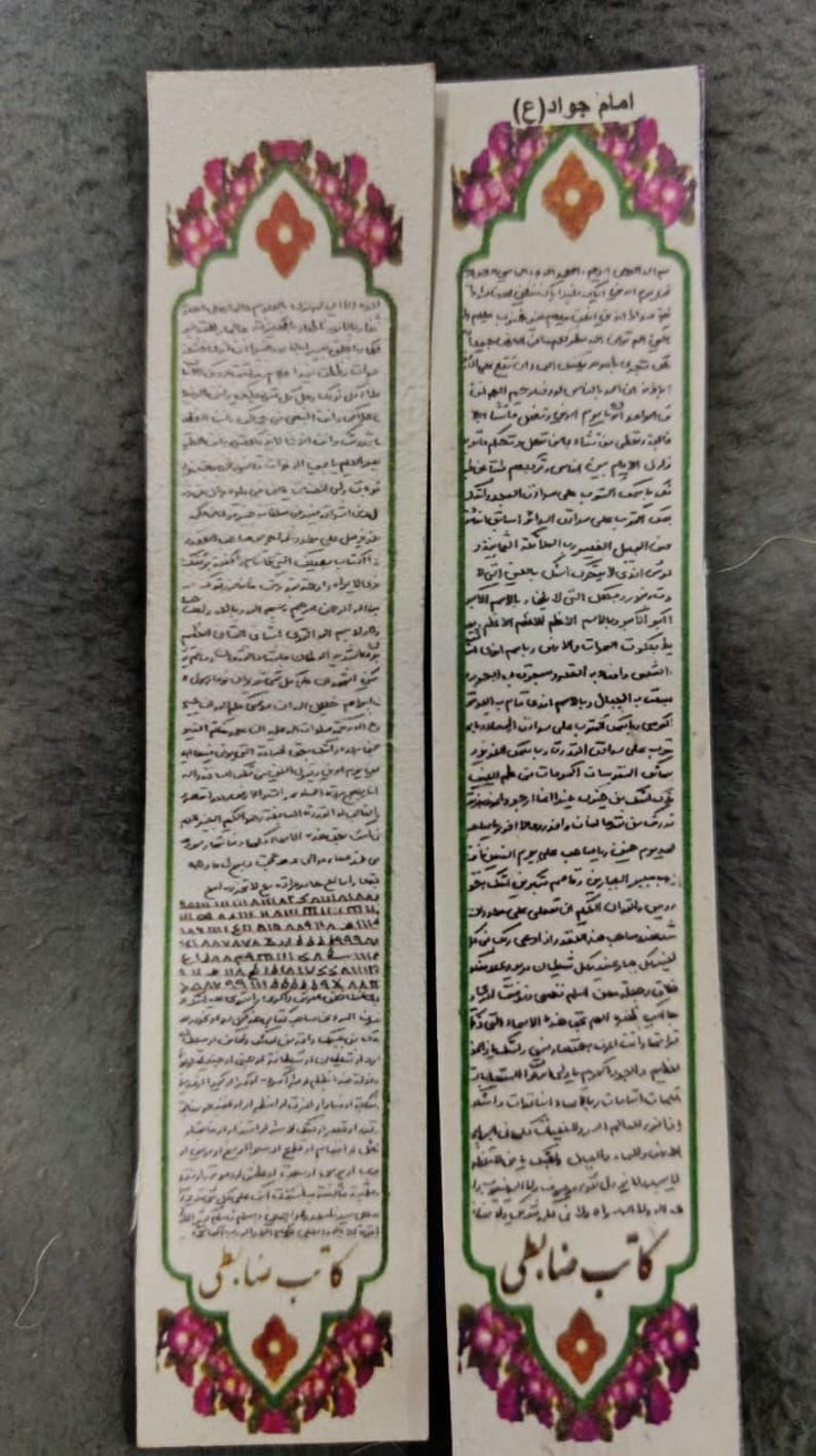 May include: Two rectangular bookmarks with ornate floral and geometric designs. The bookmarks feature Arabic script and are likely religious or cultural items. The top of each bookmark has a decorative arch.