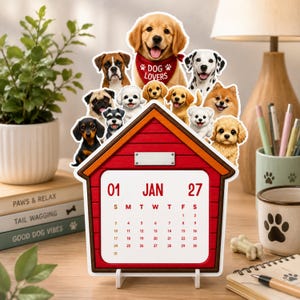Könnte beinhalten: Ein roter, hundehütten-förmiger Tischkalender für Januar 2027 mit einem Aufsatz aus verschiedenen Hunderassen. Ein Golden Retriever trägt ein rotes Halstuch mit der Aufschrift DOG LOVERS. Das Kalenderblatt zeigt die Daten vom 01. bis zum 31.