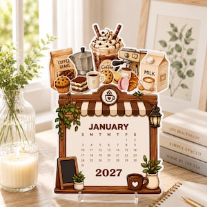 以下が含まれることがあります： コーヒーショップをテーマにした2027年1月のカレンダー。上部にはコーヒー豆、モカポット、ホイップクリームのドリンク、エスプレッソマシン、牛乳、ペストリーのイラストが描かれています。カレンダーのグリッドは、ストライプのオーニングが付いた木製のフレームで囲まれています。