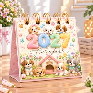 May include: A desktop spiral-bound 2027 calendar featuring illustrations of various puppies in a garden setting. The cover displays the text 2027 Calendar, a pink dog house labeled Puppy House, and multiple cartoon puppies with colorful accessories.