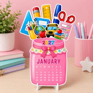 Puede incluir: Un calendario de enero de 2027 con forma de frasco rosa y un adorno escolar que incluye un autobús amarillo, una manzana roja, un globo terráqueo, una regla, tijeras, una calculadora y lápices. El calendario muestra el mes y las fechas en blanco.