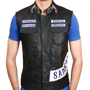 May include: Black leather vest with multiple patches. The vest has two front pockets and a button-up closure. Patches include "V.PRESIDENT MEN OF MAYHEM", "REDWOOD ORIGINAL", and "SAMCRO". The vest also features a reaper design on the collar.