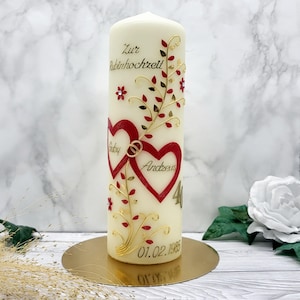 Könnte beinhalten: Elfenbeinfarbene Säulenkerze mit roten Herzmotiven, goldenen floralen Akzenten und dem Text "Zur Rubinhochzeit". Die Kerze zeigt die Namen "Gaby" und "Andreas" in den Herzen, mit dem Datum "01.02.1985" und der Zahl "40".