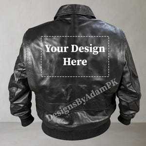 Könnte beinhalten: Schwarze Lederbomberjacke mit Reißverschluss und geripptem Strickkragen, Bündchen und Bund. Die Rückseite der Jacke hat einen weißen Textaufdruck mit der Aufschrift "Your Design Here".
