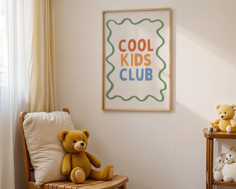 May include: A framed poster with the words "COOL KIDS CLUB" in orange, blue, and orange, with a green wavy border. A brown teddy bear sits on a wooden chair with a cream-colored pillow. A small wooden shelf holds two more teddy bears.
