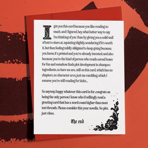 May include: A red greeting card with a white interior, featuring black text. The text begins with "I got you this card..." and concludes with "The end." A decorative floral design is in the lower right corner.