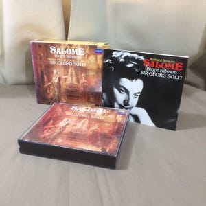 May include: Three vintage opera albums of Richard Strauss's "Salome" featuring Birgit Nilsson and Sir Georg Solti. The album covers are in various formats, including a CD case and two larger boxes, with artwork and text in English.