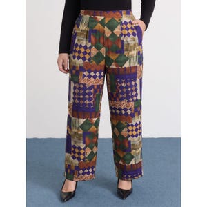 May include: High-waisted trousers featuring a vibrant patchwork pattern in shades of deep purple, forest green, mustard yellow, and brown. The design incorporates geometric diamond shapes, checkered squares, and vertical line textures throughout the fabric.