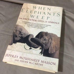 May include: A hardcover book titled When Elephants Weep: The Emotional Lives of Animals by Jeffrey Moussaieff Masson and Susan McCarthy. The cover features a photograph of two grey elephants touching trunks, with a quote by Elizabeth Marshall Thomas.