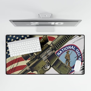 Può includere: Tappetino per mouse rettangolare con un'illustrazione dettagliata di un fucile, una bandiera americana e un emblema della Guardia Nazionale. Una tastiera e un mouse bianchi sono posizionati sul tappetino. La tavolozza dei colori include sfumature di verde, rosso, blu e bianco.