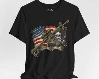 May include: Black t-shirt featuring a graphic design with an assault rifle, the American flag, and a pirate flag with a skull. The text "HOIST THE COLOURS" is displayed on a banner.
