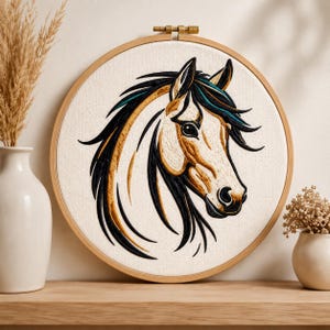 May include: A circular wooden embroidery hoop containing a fabric panel with a detailed thread-stitched portrait of a horse head. The horse features a cream-colored face with black and golden-brown mane strands and teal accents.