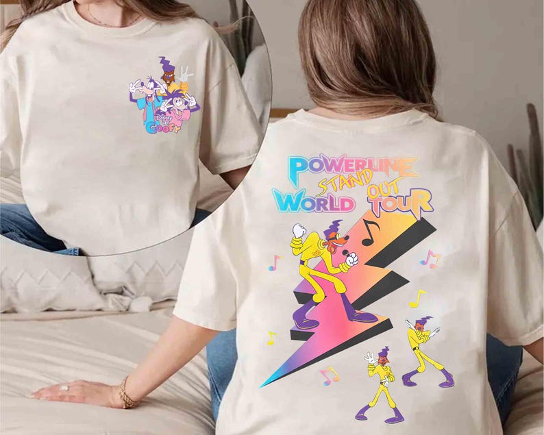 May include: White t-shirt with a cartoon character graphic on the front and "POWERLINE STAND OUT WORLD TOUR" text on the back.