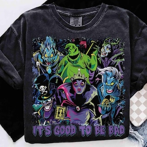 May include: Dark gray long-sleeve shirt featuring a colorful graphic of cartoon villains. The graphic includes characters in shades of green, blue, purple, and black. The text "IT'S GOOD TO BE BAD" is printed at the bottom of the graphic.