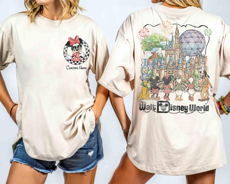 May include: Beige t-shirt featuring Minnie Mouse in a checkered circle with the text "Custom Name" on the front. The back of the shirt displays a colorful illustration of Walt Disney World with various characters and the words "Walt Disney World".