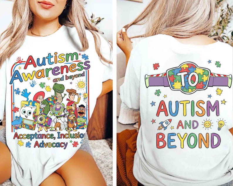 May include: White t-shirt with a colorful graphic promoting autism awareness. The front features the words "Autism Awareness and beyond" with cartoon characters. The back of the shirt says "TO AUTISM AND BEYOND" with a puzzle piece design.