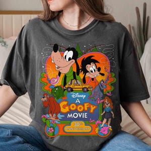 May include: A gray t-shirt with a retro-style graphic of Goofy and friends from the Disney movie "A Goofy Movie". The graphic includes the text "Disney A Goofy Movie 30th Anniversary".