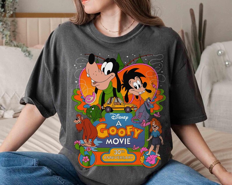 May include: A gray t-shirt with a retro-style graphic of Goofy and friends from the Disney movie "A Goofy Movie". The graphic includes the text "Disney A Goofy Movie 30th Anniversary".