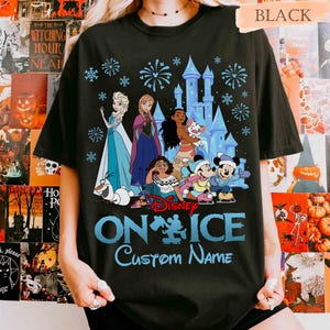 Puede incluir: Camiseta negra con un dise&ntilde;o azul que presenta personajes de Disney de Frozen, Moana y Mickey Mouse, un castillo y fuegos artificiales. El texto dice "Disney On Ice" y "Custom Name" en azul.