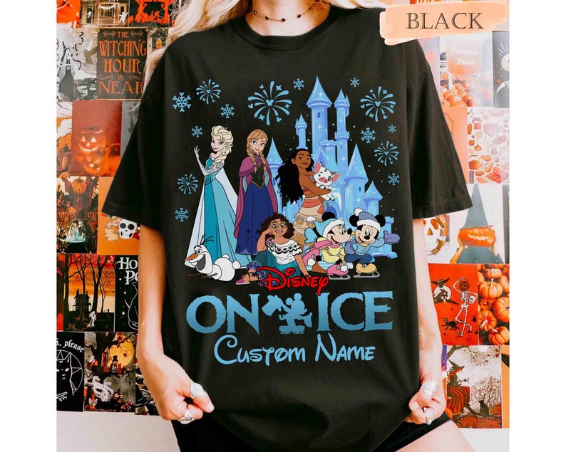 Puede incluir: Camiseta negra con un dise&ntilde;o azul que presenta personajes de Disney de Frozen, Moana y Mickey Mouse, un castillo y fuegos artificiales. El texto dice "Disney On Ice" y "Custom Name" en azul.