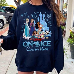 Puede incluir: Sudadera azul marino con personajes de Disney sobre hielo. El dise&ntilde;o incluye a Elsa, Anna, Moana, Mickey y Minnie Mouse, con un castillo y fuegos artificiales. El texto "Disney ON ICE Custom Name" est&aacute; impreso en azul claro.