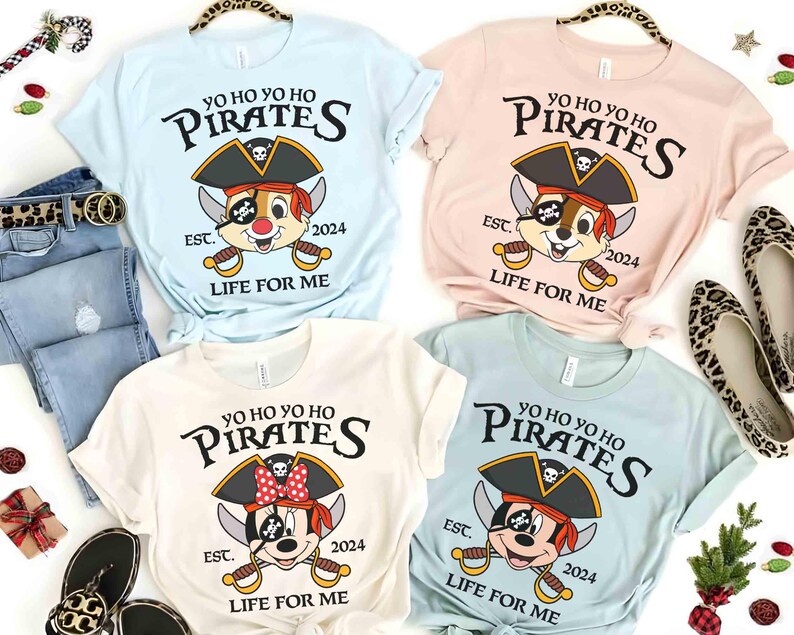May include: Four t-shirts with a pirate theme. The shirts are light blue, pink, white, and blue. Each shirt features a cartoon character wearing a pirate hat and holding a sword. The text on the shirts reads "Yo Ho Yo Ho Pirates Est. 2024 Life For Me".