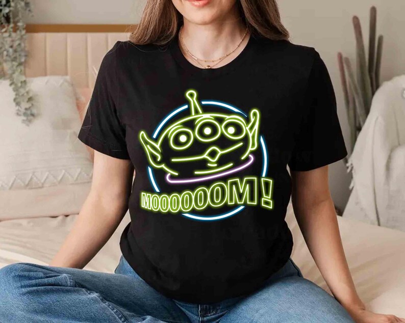 May include: Black t-shirt with a neon green alien character and the text "Mooooom!" in neon green and yellow.