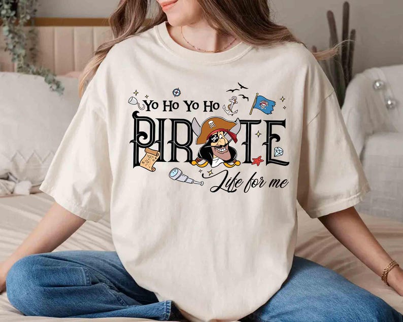 Peut inclure: T-shirt cr&egrave;me avec un motif sur le th&egrave;me des pirates. Le design comprend le mot "PIRATE" dans une police stylis&eacute;e, un personnage de pirate de dessin anim&eacute; et la phrase "Life for me". Des illustrations suppl&eacute;mentaires sur le th&egrave;me des pirates, telles qu'une ancre, un drapeau et une longue-vue, sont &eacute;galement pr&eacute;sentes.