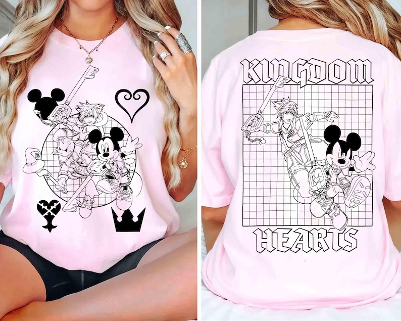 Puede incluir: Camiseta rosa claro con un gr&aacute;fico en blanco y negro de Mickey Mouse, Donald Duck y Sora de Kingdom Hearts. El dise&ntilde;o frontal incluye una llave, un coraz&oacute;n y una corona. La parte trasera de la camiseta muestra las palabras "Kingdom Hearts" con una ilustraci&oacute;n de personaje.