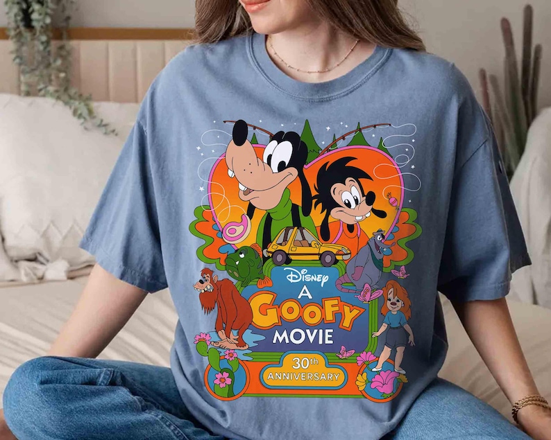 May include: A blue t-shirt with a graphic of Goofy and other Disney characters from the movie "A Goofy Movie". The graphic includes the text "Disney A Goofy Movie 30th Anniversary".