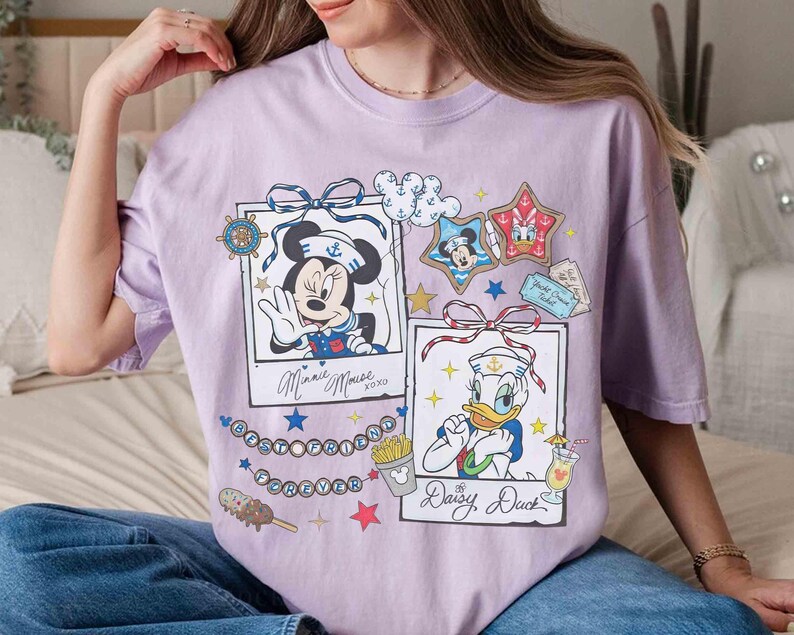 May include: A light purple t-shirt featuring two framed illustrations of Disney characters Minnie Mouse and Daisy Duck. The shirt includes the text "Best Friends Forever" and other nautical-themed graphics.