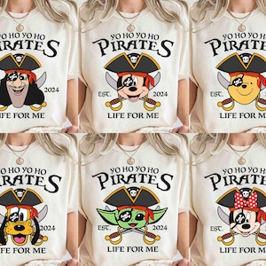 May include: Six white t-shirts with a pirate theme. Each shirt features a different cartoon character, including Mickey Mouse, Donald Duck, Goofy, and Minnie Mouse. The shirts all have the text "Yo Ho Yo Ho Pirates" and "Life for Me" printed on them.