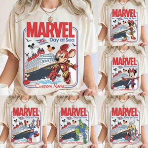 May include: Cream-colored t-shirts featuring Marvel characters and the text "MARVEL Day at Sea." Each shirt showcases a different character, including Mickey Mouse, Minnie Mouse, Donald Duck, Captain America, Hulk, and Thor, with a cruise ship graphic.