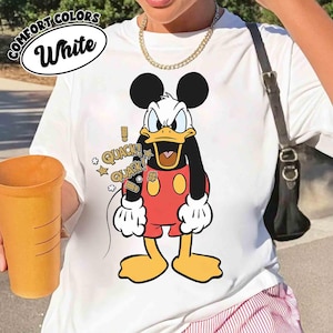 May include: White t-shirt with a cartoon Donald Duck design. Donald Duck is depicted with an angry face, wearing a red shirt and shorts. The shirt includes the text "COMFORT COLORS" and "White" in a circular design.