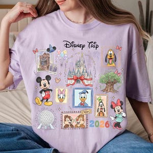 Puede incluir: Camiseta lila claro con un dise&ntilde;o de "Disney Trip". El gr&aacute;fico incluye ilustraciones de Mickey Mouse, Minnie Mouse, Donald Duck, Pluto y Chip y Chop, junto con un castillo y el a&ntilde;o 2026.