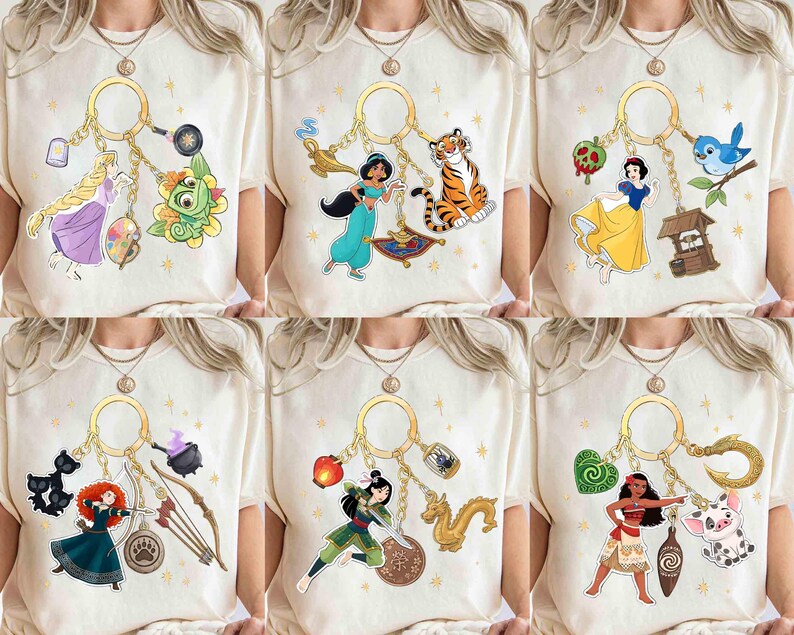 May include: Cream-colored t-shirts featuring various Disney character keychains. Each keychain includes a character and related items, such as a magic lamp, a tiger, a well, a bow and arrow, a dragon, and a pig. The designs are colorful and detailed.